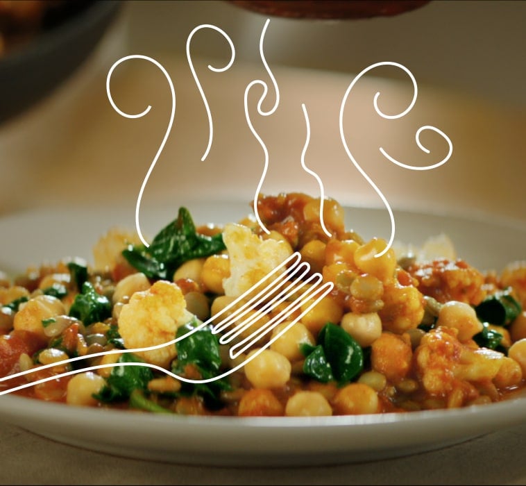 Teller mit gekochten Kichererbsen, Blumenkohl und Spinat, Abbildung von Dampf aufsteigend vom Teller